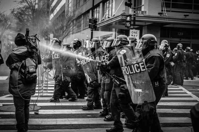 Ein Journalist der schwer bewaffnete Polizisten filmt
