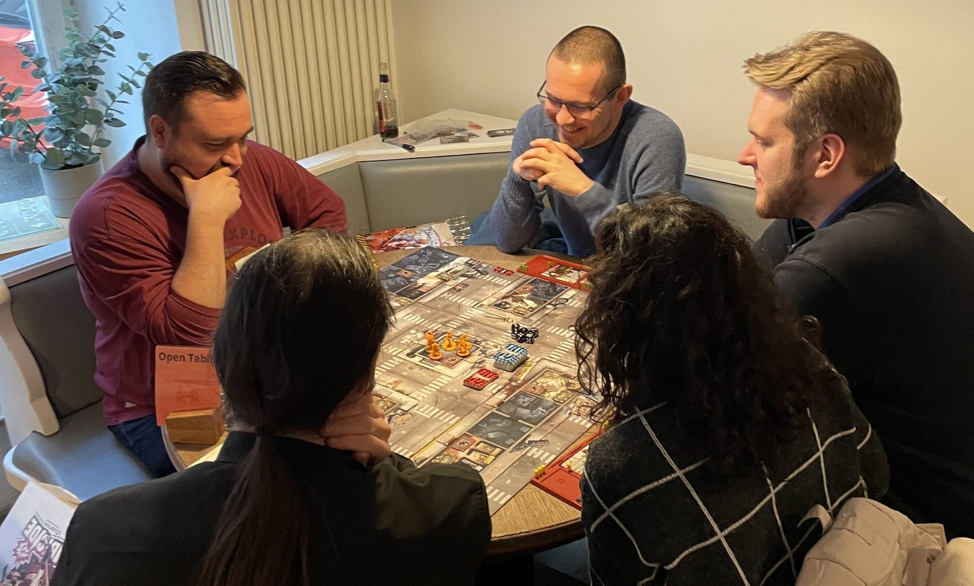 Eine Gruppe spielt ein Brettspiel im Spielecafé Playce